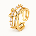 An open gold-tone ring with intersecting lines and clear stone details — studio view | Jeweliano