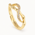 A gold-tone ring with an infinity-inspired silhouette and a line of clear stones — studio view | Jeweliano