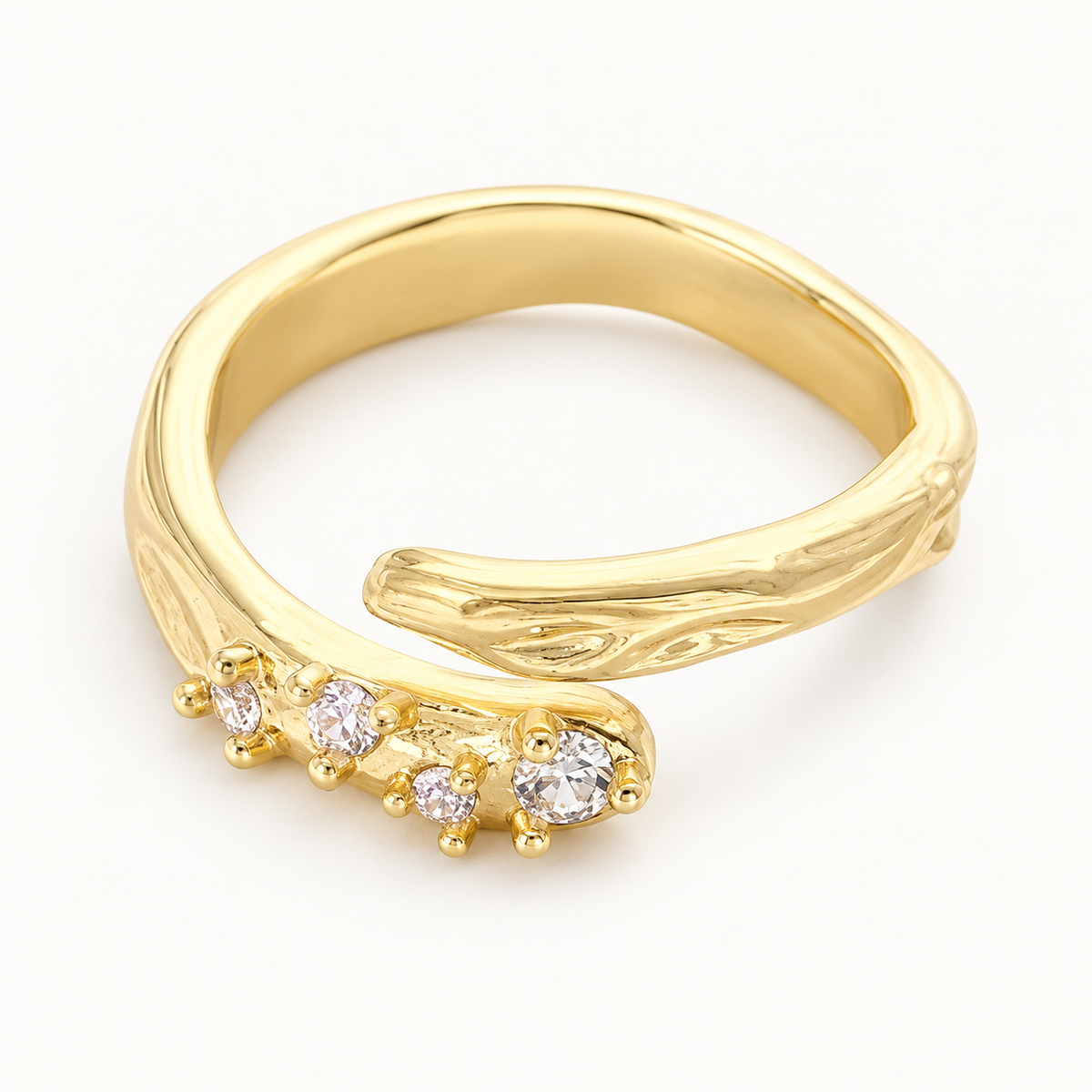 An open gold-tone ring pairing a textured band with a cluster of clear stones — studio view | Jeweliano