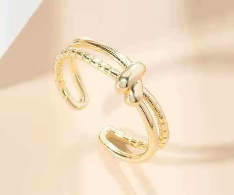 An open gold-tone ring with a central knot and contrasting smooth and beaded lines — alternate view | Jeweliano