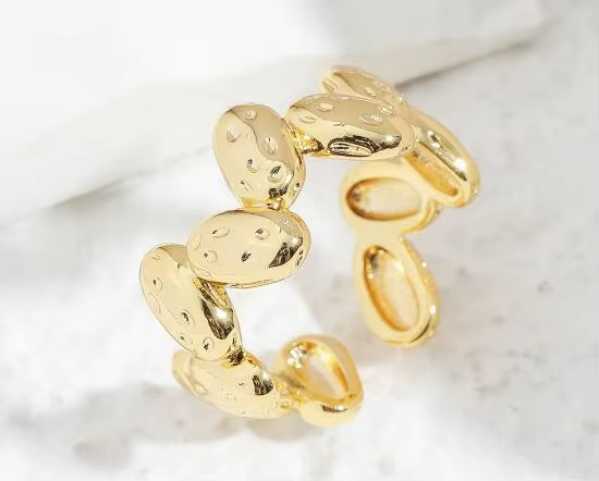 An open gold-tone ring with a sequence of rounded, textured disc details — alternate view | Jeweliano