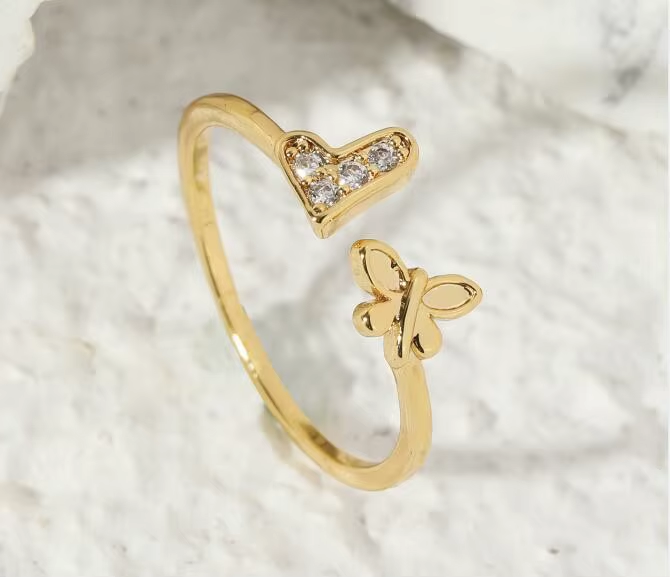 An open gold-tone ring combining a stone-set heart and a butterfly-inspired detail — alternate view | Jeweliano